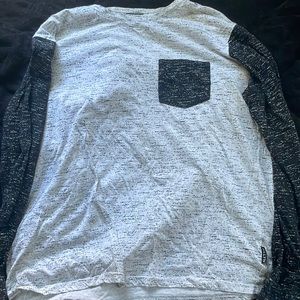 A Long sleeve shirt with black arms and white with speckle all over